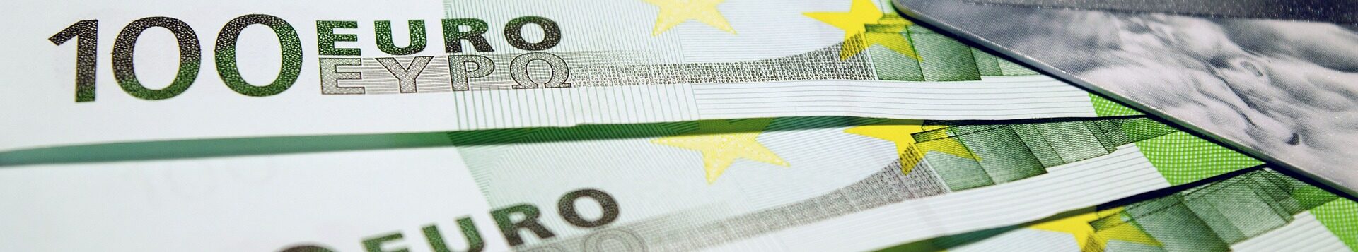 100-Euro-Scheine und eine Kreditkarte liegen aufgefächert auf einem Tisch, Nahaufnahme