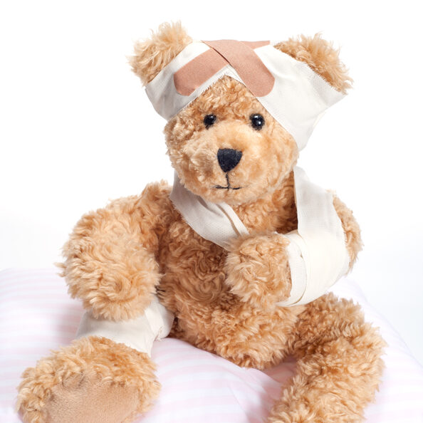 Ein Teddybär mit verbundenem Arm, Kopfbandage und Pflaster