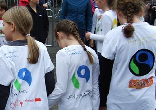 Kinder mit beschrifteten Tshirts mit dem Fair Trade Logo