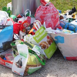 Viele unterschiedliche Tüten mit Müll und Abfall, wie Plastiktüten, Pappkartons, Dosen, Flaschen.