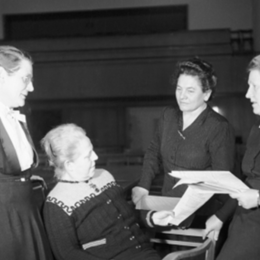 Schwarz-Weiß-Foto: Vier Damen unterhalten sich miteinander